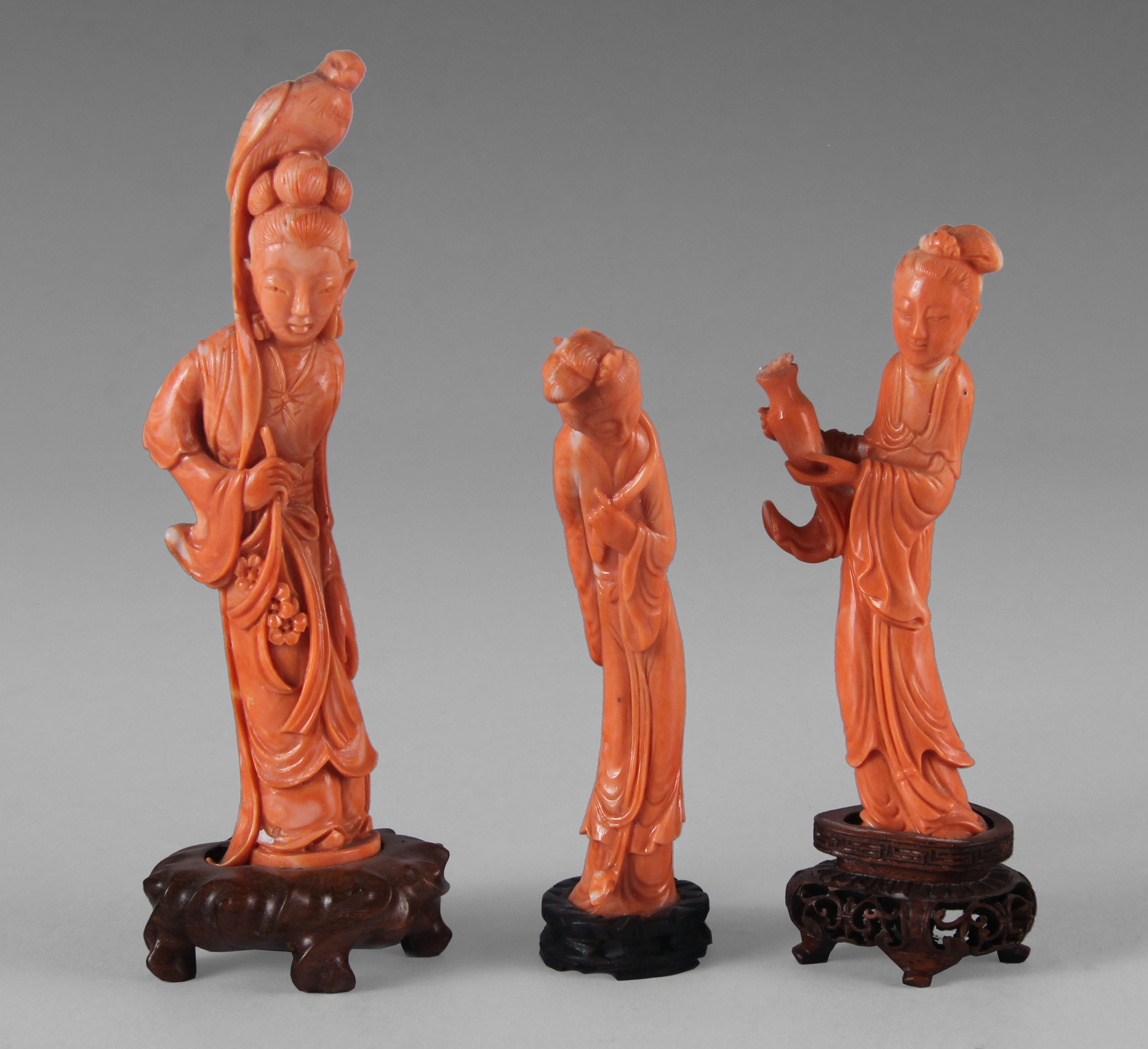  TRES FIGURAS CHINAS DE CORAL ESCULPIDO.