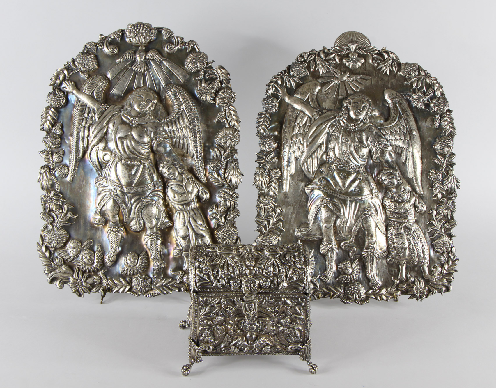 Lotes 580 y 579: 
																		PAR DE ANTIGUAS PLACAS VIRREYNALES ANDINAS REPUJADAS.
																		ANTIGUO COFRE COLONIAL CINCELADO Y REPUJADO CON TAPA.