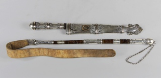 Lotes 594 y 595: 
																		IMPORTANTE CUCHILLO CINCELADO OBRA DEL PLATERO CUENCA.
																		REBENQUE CRIOLLO O LATIGO DE MONTAR CINCELADO.